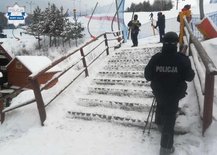 policjant w poblizu schodow na terenie stacji narciarskiej