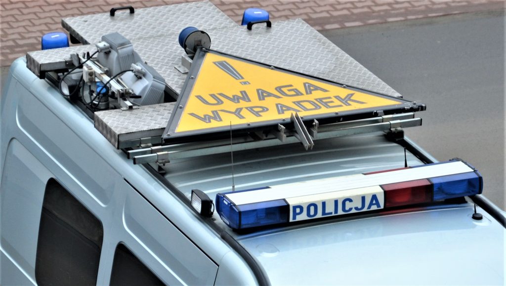 fragment radiowozu zespolu wypadkowego WRD na dachu pojazdu zolty znak ostrzegawczy z napisem uwaga wypadek