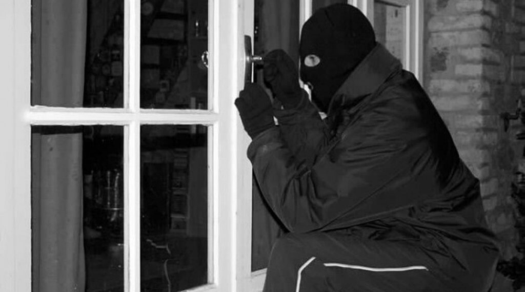wlamzamaskowany mezczyzna probuje dostac sie do wnetrza domu fot. Mazowiecka Policja