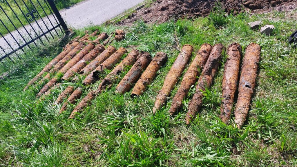 niewybuchy ulozone na trawie przy ogrodzieniu