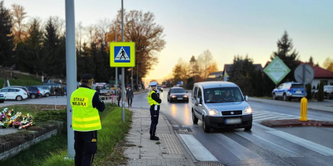 policjantka wspolnie z straznikiem miejskim dbaja o bezpieczenstwo w poblizu przejscia dla pieszych i cmentarza