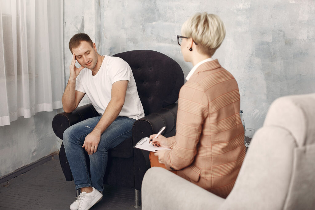 man sitting psychologist s office talking about problems