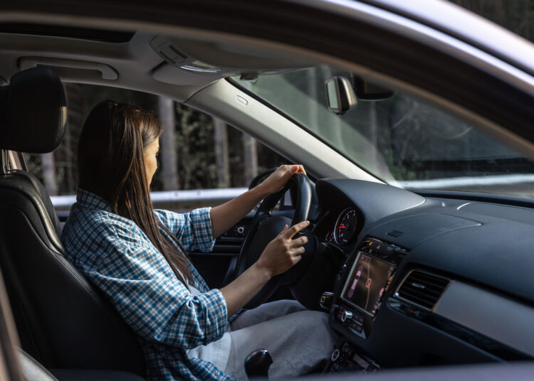 woman driving car forest mountain travel concept