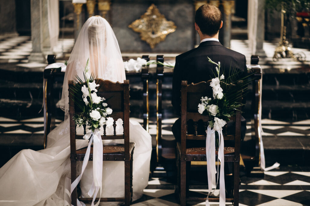 bride groom sitting chairs their wedding day from back