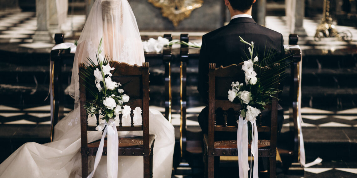 bride groom sitting chairs their wedding day from back