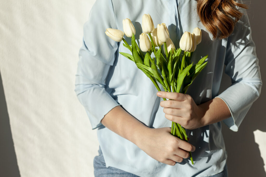 unrecognizable woman holding tulips