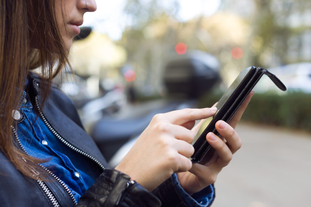 piekne mloda kobieta przy uzyciu jej telefonu komorkowego na ulicy