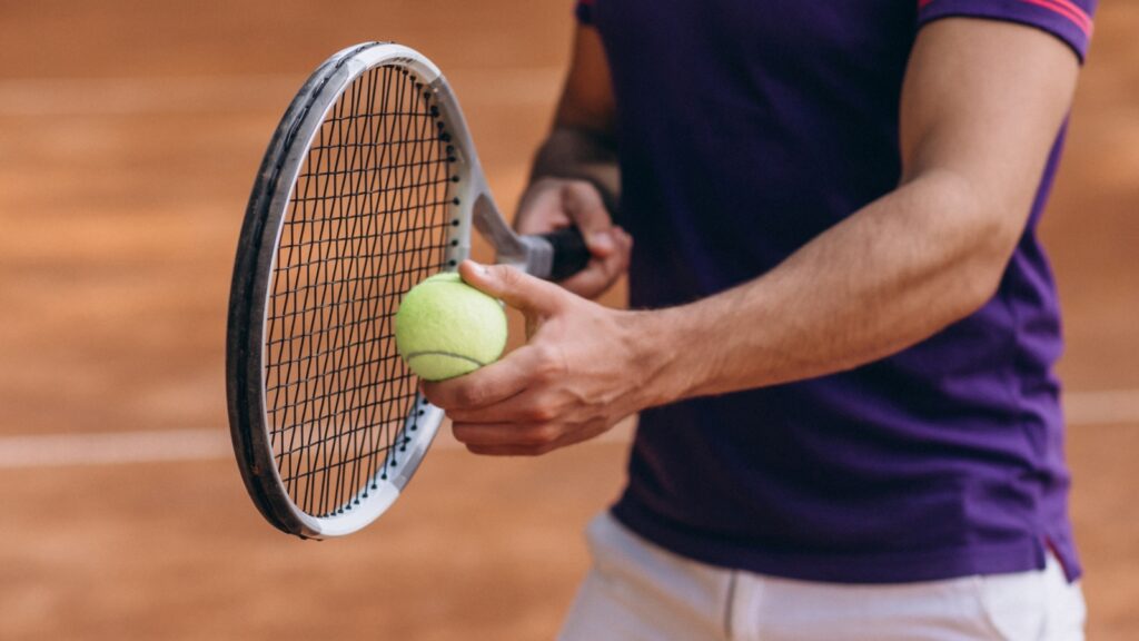 young man tennis player court tennis racket close up
