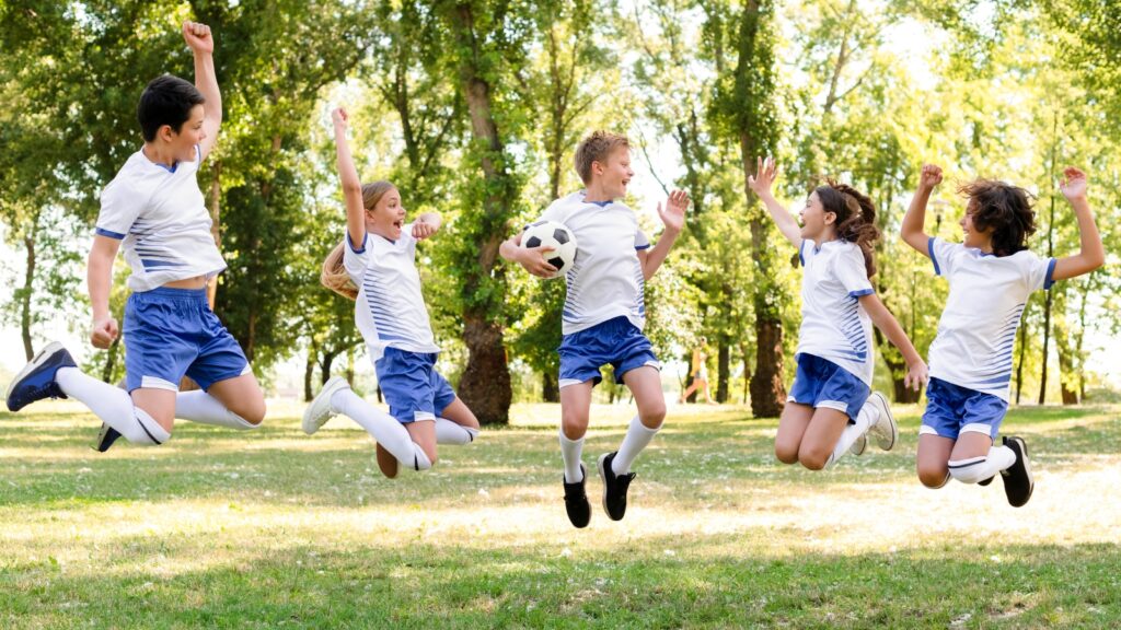 dzieci w sportowej odziezy skaczacej na zewnatrz