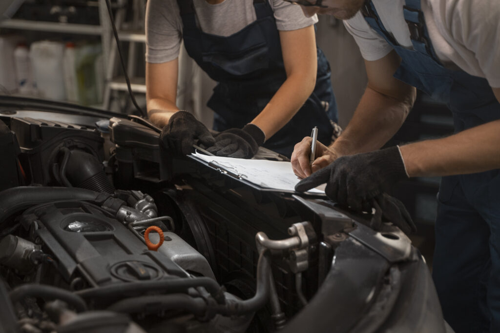 mechanicy plci meskiej i zenskiej pracujacy w sklepie przy samochodzie