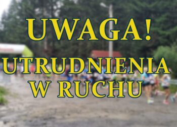 napis UWAGA UTRUDNIENIA W RUCHU w tle rozmyte zdjecie biegaczy