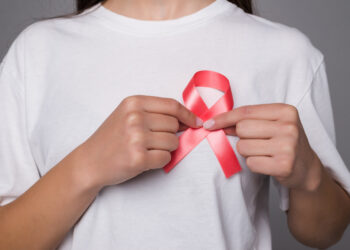 World Breast Cancer Day Concept,health care - woman wore white t-shirt with Pink ribbon for awareness, symbolic bow color raising on people living with women's breast tumor illness