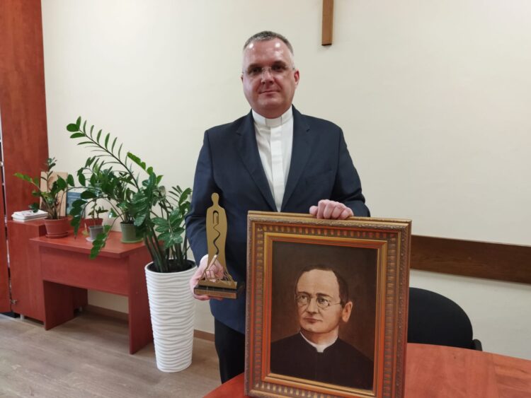 na zdjęciu: ks. Andrzej Jasnos prezentuje statuetkę i obraz ks. Walentego Gadowskiego