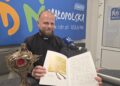 Na zdjęciu: ks. Jan Kurek z relikwiarzem i jubileuszową publikacją, w której jest także dokument lokacyjny