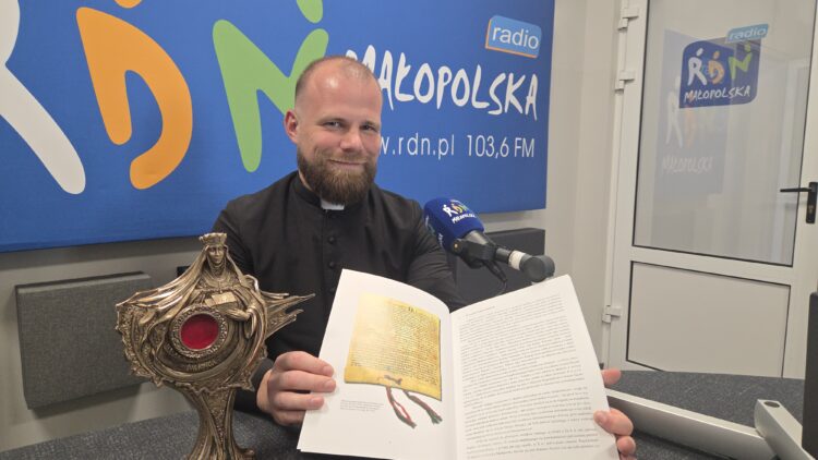 Na zdjęciu: ks. Jan Kurek z relikwiarzem i jubileuszową publikacją, w której jest także dokument lokacyjny